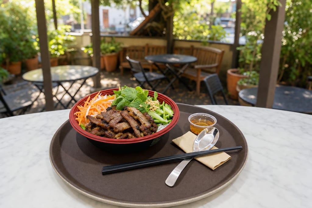 Pork fresh bowl: charred sliced pork, crushed peanuts, pickles, cucumber and mint in a red bowl on a tray with nuoc cham