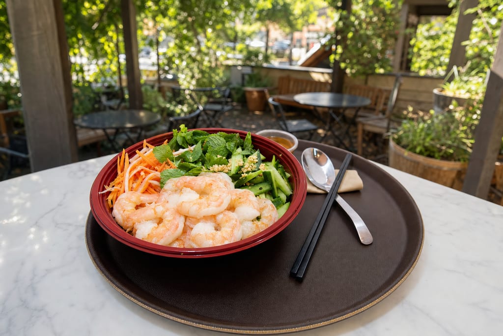 Shrimp fresh bowl: plump pink shrimp, crushed peanuts, pickles, cucumber and mint in a red bowl on a tray with chopsticks